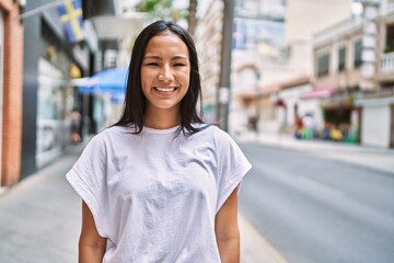 Wall Mural - Young latin girl smiling happy standing at the city.