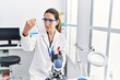 © Krakenimages.com - Young hispanic woman wearing scientist uniform holding test tube at laboratory