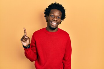 Poster - Young african american man wearing casual clothes smiling with an idea or question pointing finger up with happy face, number one