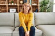 © Krakenimages.com - Middle age caucasian woman wearing casual clothes sitting on the sofa at home with serious expression on face. simple and natural looking at the camera.