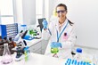 © Krakenimages.com - Young hispanic woman wearing scientist uniform using pipette and test tube working at laboratory