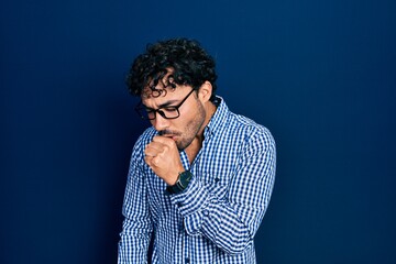 Wall Mural - Young hispanic man wearing casual clothes and glasses feeling unwell and coughing as symptom for cold or bronchitis. health care concept.