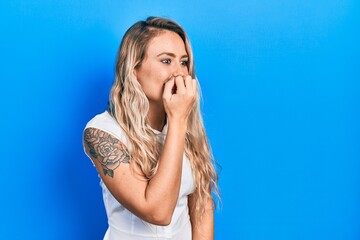 Canvas Print - Beautiful young blonde woman wearing casual white shirt looking stressed and nervous with hands on mouth biting nails. anxiety problem.