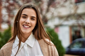 Young hispanic businesswoman smiling happy standing at the city.