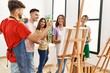 © Krakenimages.com - Group of people smiling happy drawing on canvas standing at art studio.