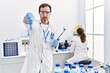 © Krakenimages.com - Middle age man working at scientist laboratory with angry face, negative sign showing dislike with thumbs down, rejection concept