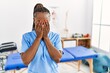 Black woman with braids working at pain recovery clinic rubbing eyes for fatigue and headache, sleepy and tired expression. vision problem