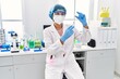 © Krakenimages.com - Young latin woman wearing scientist uniform holding vaccine at laboratory