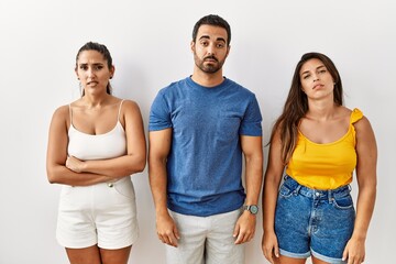 Poster - Group of young hispanic people standing over isolated background looking sleepy and tired, exhausted for fatigue and hangover, lazy eyes in the morning.