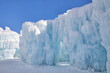 Clear blue sky on a winter day with huge icicles dripping on a giant frozen snow fort