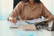 © Prathankarnpap - Cropped shot businesswoman holding financial document and using calculator.