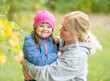 © Ermolaev Alexandr - Mother hugs her little girl with Down syndrom at autumn park