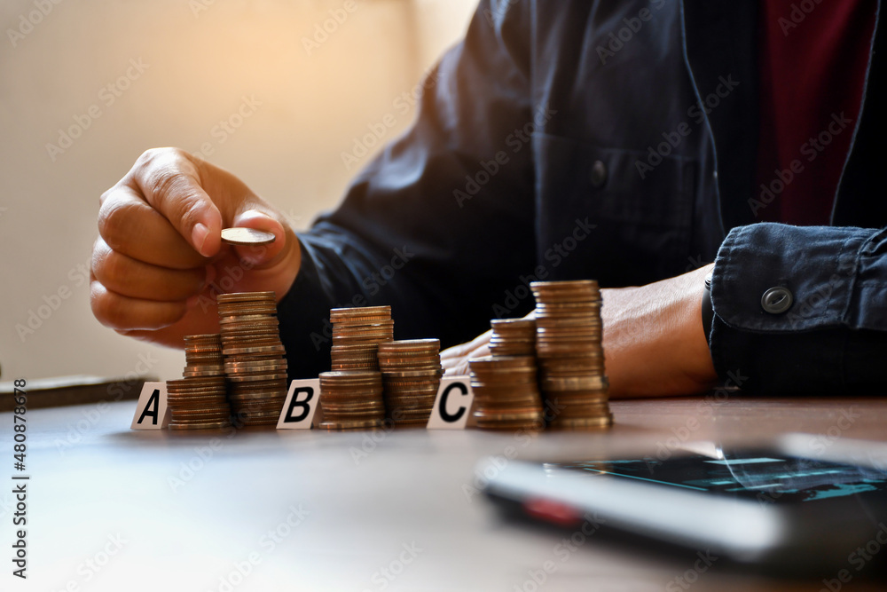 Human hand stacking coins for finance investment management by portfolio diversification for distributing risks