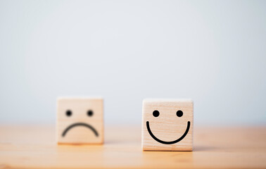 Wall Mural - Focus of Smile face and defocus of sad face on wooden block cube for positive mindset selection concept.