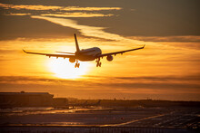 Airplane Landing To Airport Runway In Sunset