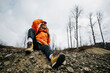 © Westend61 - Hiker wearing orange jacket shielding eyes
