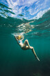 © Westend61 - Carefree young woman swimming undersea