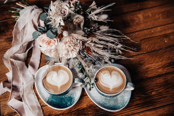 Coffee in beautiful cups with foam, hearts and flowers. Valentine's Day background 