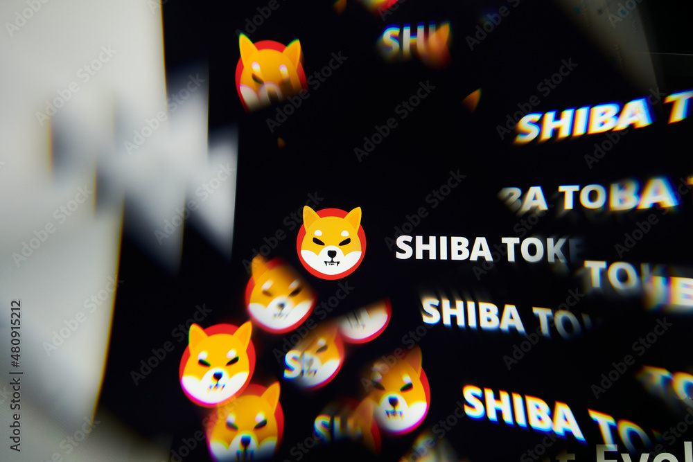 Milan, Italy - January 11, 2022: shiba inu - SHIB logo on laptop screen seen through an optical prism. Dynamic and unique image form shiba inu, SHIB coin website. Illustrative editorial.
