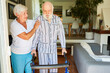 Altenpflegerin hilft Senior beim Gehen mit dem Rollator