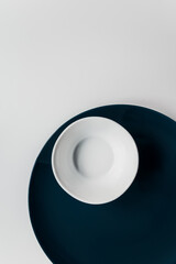 minimalism. set of dark blue large plate and white small bowl on a white background. restaurant concept