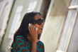 Asian woman talking on her mobile phone in summer sunshine