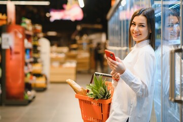 Wall Mural - Woman grocery shopping and looking very happy