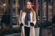 © Petro - Woman in coat standing outside the cafe in a winter street