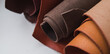 Rolls of genuine brown leather on a white background. Materials for leather goods. Manufacturing of leather goods. Banner