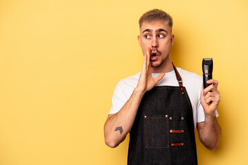 Wall Mural - Young caucasian hairdresser man isolated on yellow background is saying a secret hot braking news and looking aside