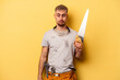 Young electrician caucasian man isolated on yellow background confused, feels doubtful and unsure.