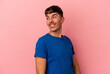 © Asier - Young mixed race man isolated on pink background looks aside smiling, cheerful and pleasant.