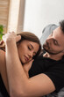 © LIGHTFIELD STUDIOS - young man embracing pretty woman sleeping on his chest at home.