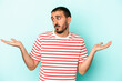 © Asier - Young caucasian man isolated on blue background confused and doubtful shrugging shoulders to hold a copy space.