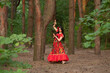 Gypsy woman. Red long dress. Portrait of a girl in an ethnic costume in the forest. The gypsy brunette is beautiful.