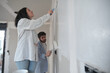 © Ladanifer - Young couple painting walls in their new house in construction.