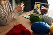 © gpointstudio - Close up of caucasian senior woman at home learning how to knit from video tutorial