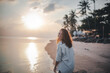 © olezzo - Portrait of a beautiful young woman in a white shirt at sunset on a tropical beach