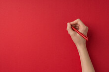 First Person Top View Photo Of Valentine's Day Decorations Female Hand Holding Red Pen On Isolated Red Background With Blank Space