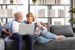© offsuperphoto - senior couple using laptop computer and tablet on sofa
