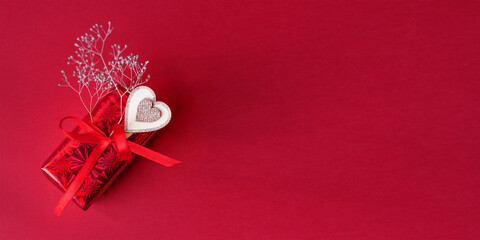 Wall Mural - gift box with bow on red background with hearts. Flat lay, top view, copy space. banner