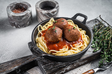 Vegan tomato pasta with plant based Meatballs in a skillet. White background. Top view