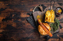Currywurst Bratwurst Sausage In A Bun With Curry Sauce And French Fries. Wooden Background. Top View. Copy Space