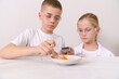 © ALEKSANDR - A boy and a girl look at a chemical volcano