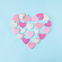 Canvas Print - Pink and white hearts arranged in the shape of a large heart. Minimalist concept of love on a blue background