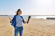 © Valerii Honcharuk - Middle aged woman on the beach talking online using smartphone.