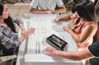 © STOCKEROcr - Grupo de profesionales analizando planos constructivos e imágenes de un proyecto en una tableta