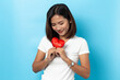 © suriya - Love and valentines day, asian girl holding red heart shape isolated on blue background