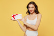 © ViDi Studio - Smiling happy caucasian young brunette woman 20s in white underwear with perfect fit body hold gift certificate coupon voucher card for store isolated on plain yellow color background studio portrait.