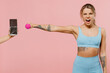 Young strong sporty athletic fitness trainer instructor woman wear blue tracksuit spend time in home gym scream reject chocolate hold dumbbells isolated on plain pink background Workout sport concept